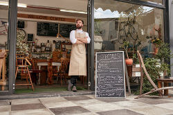 Cafebesitzer vor seinem Cafe