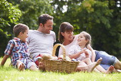 Eine Familie picknickt im Grünen