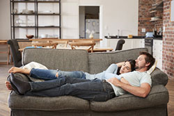 Paar liegt entspannt auf der Couch