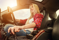 Junge Frau freut sich beim Autofahren