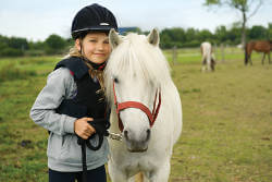 Kind mit Pferd auf Weide